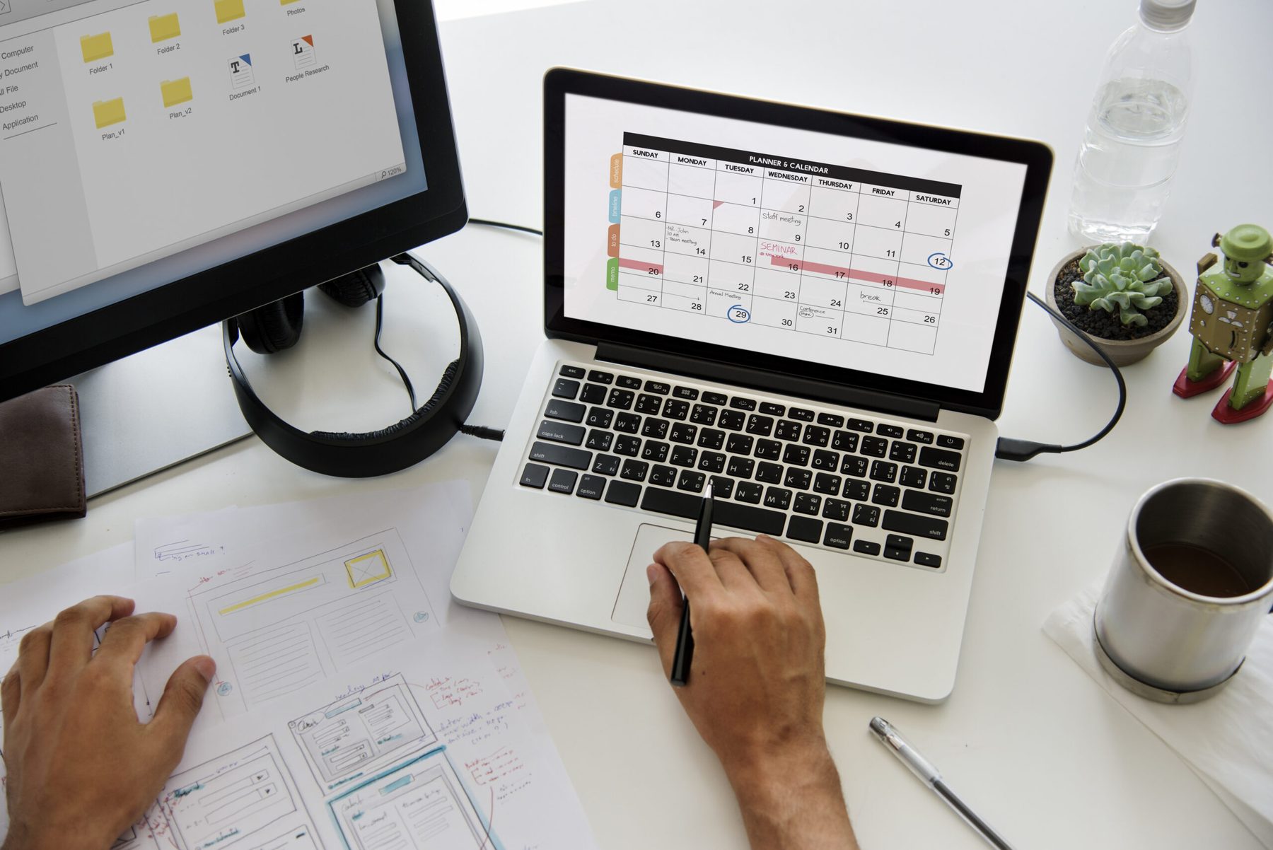 Arbeitsplatz mit digitalem Terminkalender auf Laptop und Bildschirm