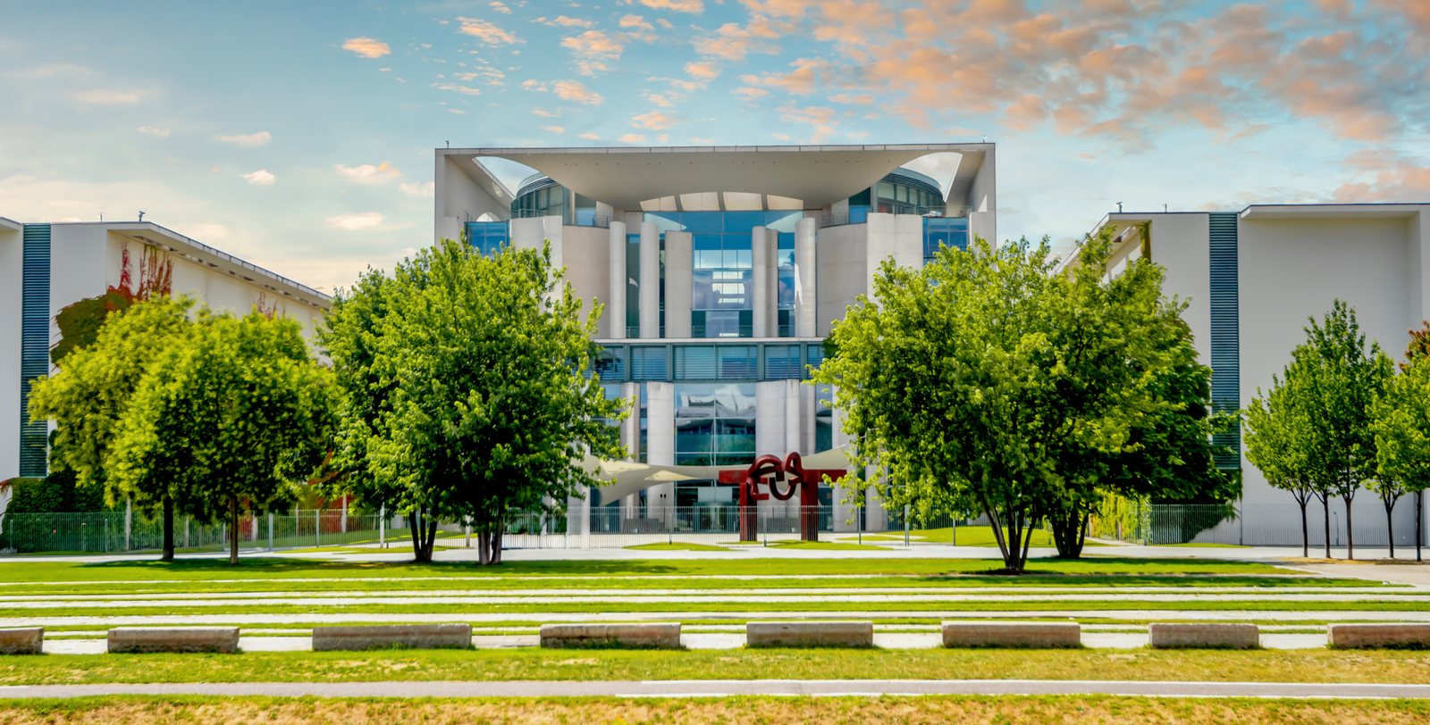 Das Bundeskanzleramt in Berlin hinter der Baumreihe im Spreebogenpark